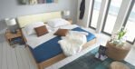 flaches Bett aus Holz mit blauem Laken
