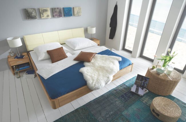 flaches Bett aus Holz mit blauem Laken