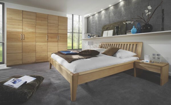 Bett aus Holz in modernem Zimmer mit brauner Decke 